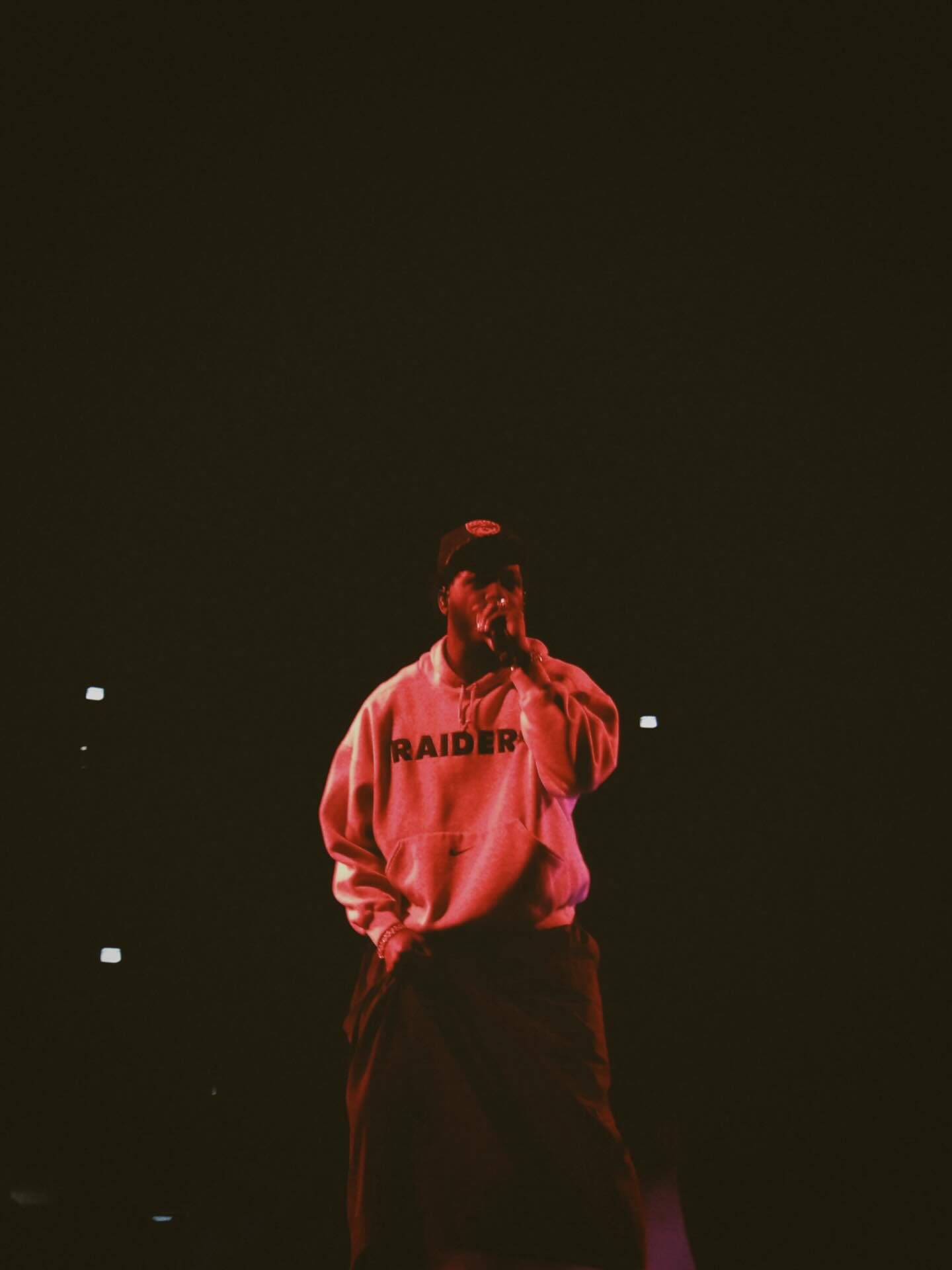Concert stage washed in orange light with a performer in silhouette