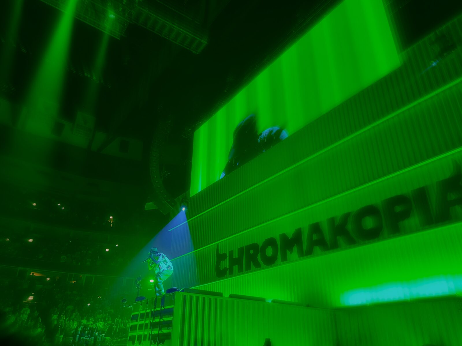 Concert venue glowing green beneath overhead signage