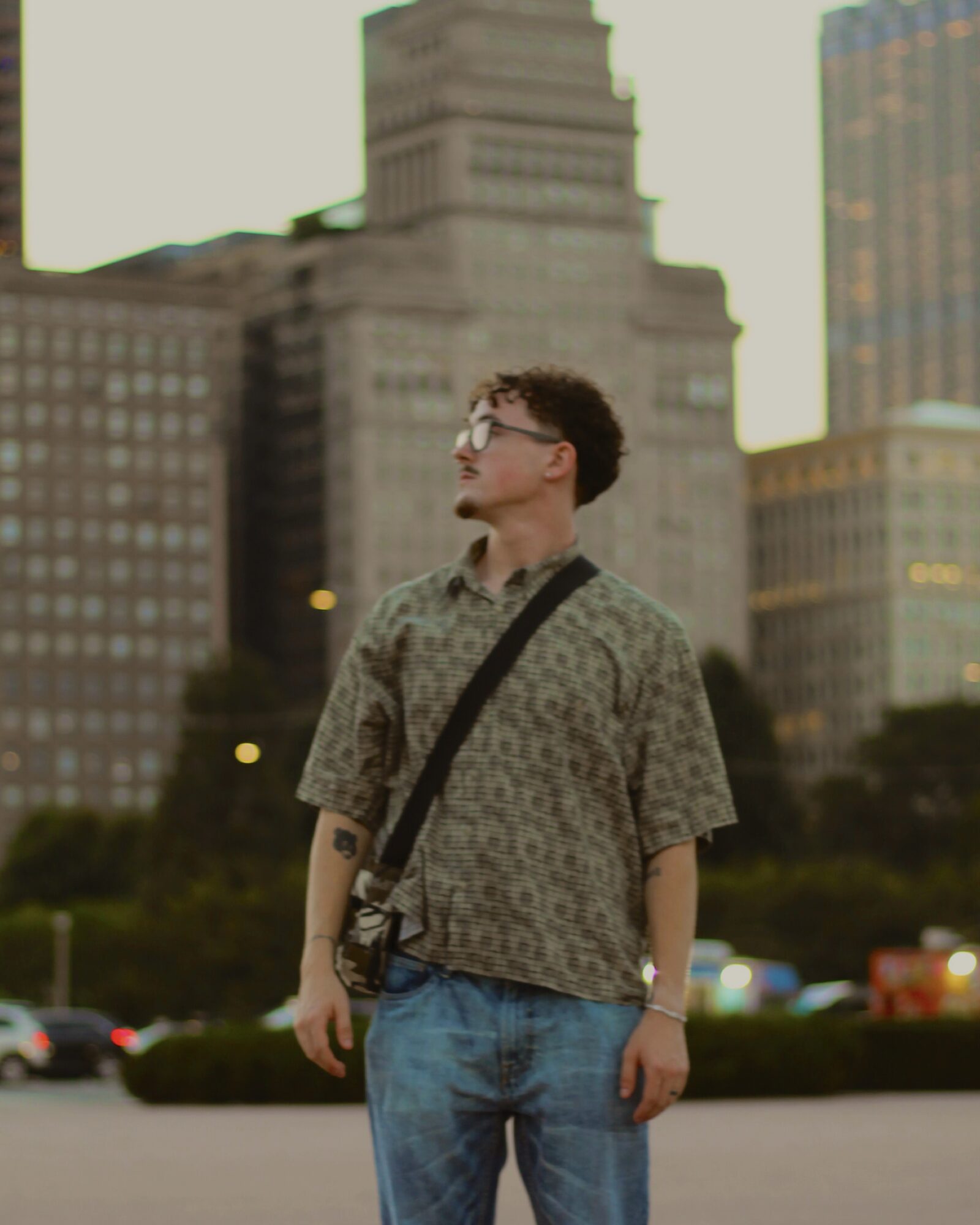 Portrait of a man standing in a downtown plaza with the skyline behind him