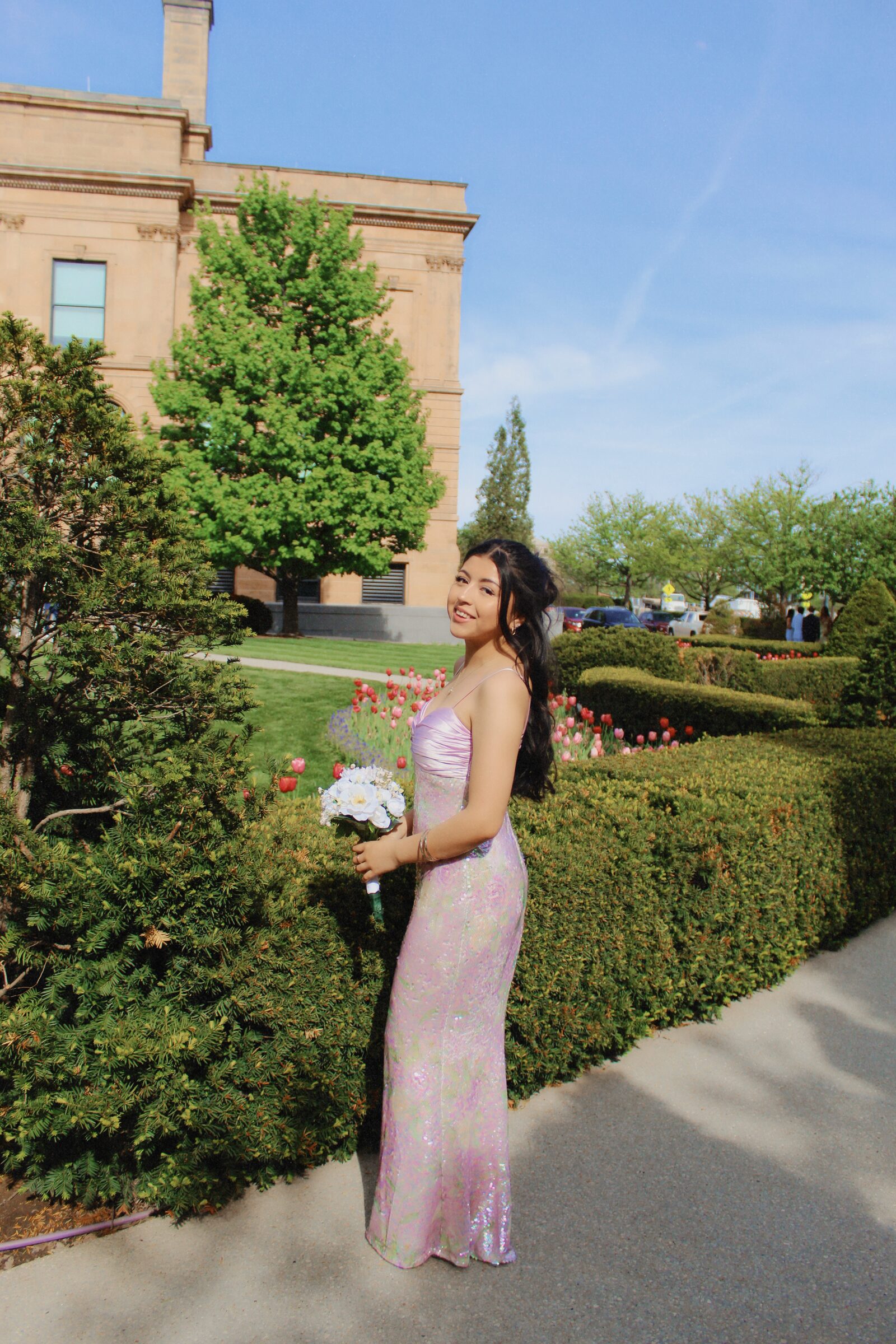 Portrait subject seated alone on a broad green lawn